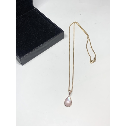 597 - A 14 CARAT GOLD NECLACE WITH AN OPAQUE STONE TEAR DROP PENDANT IN A PRESENTATION BOX