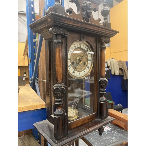 67 - AN EARLY MAHOGANY CASED WALL CLOCK WITH ENAMEL AND GILT FACE, CARVING TO THE COLUMNS AND TOP, ENDULU... 