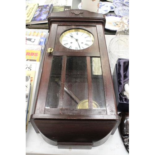 256 - A MAHOGANY CASED WALL CLOCK WITH PENDULUM AND KEY