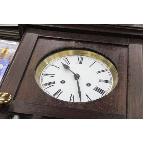 256 - A MAHOGANY CASED WALL CLOCK WITH PENDULUM AND KEY