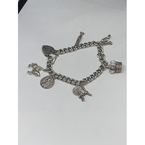 562 - A HEAVY SILVER CHARM BRACELET WITH SIX CHARMS