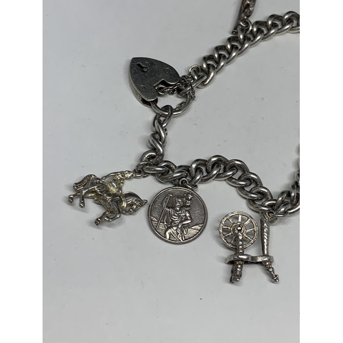 562 - A HEAVY SILVER CHARM BRACELET WITH SIX CHARMS