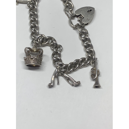 562 - A HEAVY SILVER CHARM BRACELET WITH SIX CHARMS