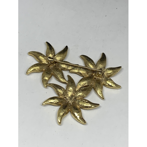 574 - A YELLOW METAL AND RHINESTONE FLOWER DESIGN BROOCH