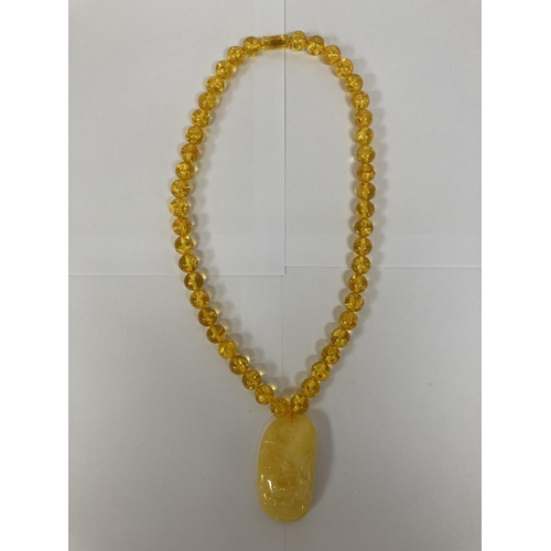 695 - AN AMBER NECKLACE AND PENDANT