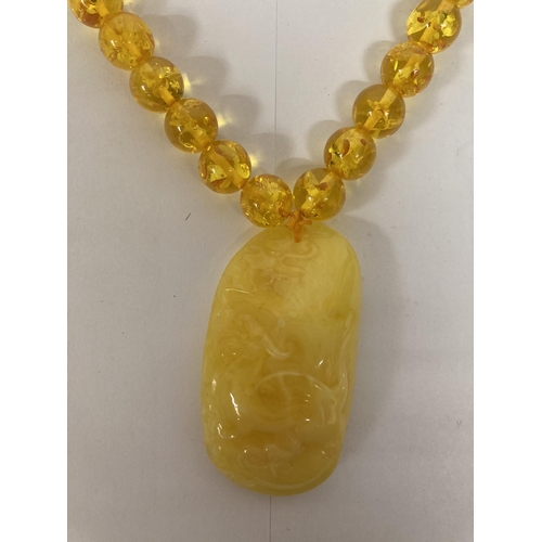 695 - AN AMBER NECKLACE AND PENDANT