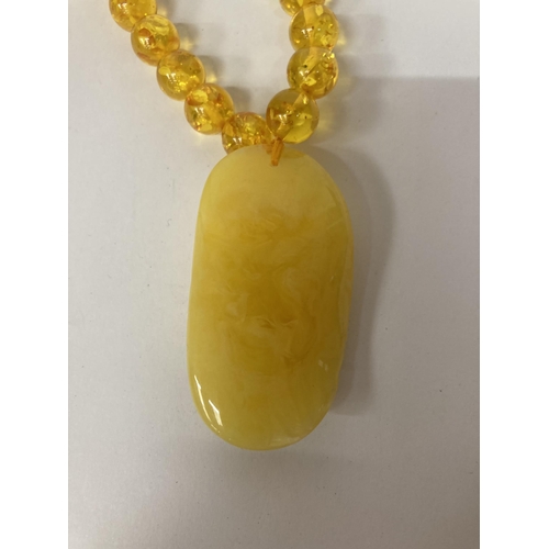 695 - AN AMBER NECKLACE AND PENDANT