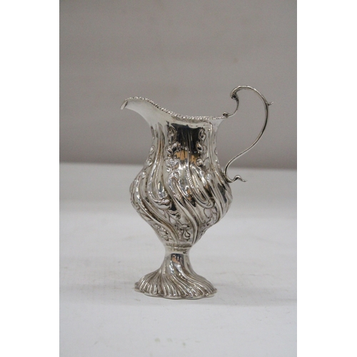 14 - A HALLMARKED BIRMINGHAM SILVER CREAM JUG WITH BALUSTER SHAPED BODY EMBOSSED WITH PANELS OF FLOWERING... 