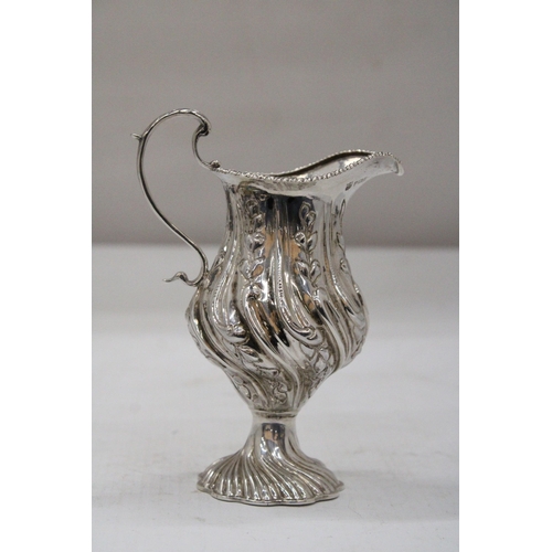 14 - A HALLMARKED BIRMINGHAM SILVER CREAM JUG WITH BALUSTER SHAPED BODY EMBOSSED WITH PANELS OF FLOWERING... 