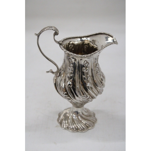 14 - A HALLMARKED BIRMINGHAM SILVER CREAM JUG WITH BALUSTER SHAPED BODY EMBOSSED WITH PANELS OF FLOWERING... 