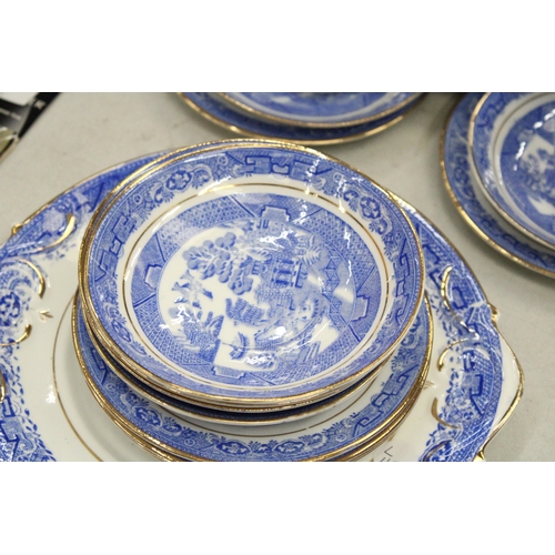 174 - A QUANTITY OF ANTIQUE BLUE WILLOW WITH GOLD TRIM TO INCLUDE SLOP BOWL, MILK JUG, CUPS, SAUCERS, SIDE... 