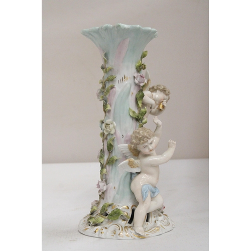 23 - AN EARLY 20TH CENTURY CONTINENTAL PORCELAIN FLORAL ENCRUSTED CANDLESTICK SURMOUNTED BY CHERUB FIGURE... 