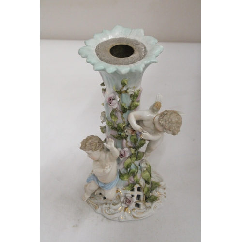 23 - AN EARLY 20TH CENTURY CONTINENTAL PORCELAIN FLORAL ENCRUSTED CANDLESTICK SURMOUNTED BY CHERUB FIGURE... 