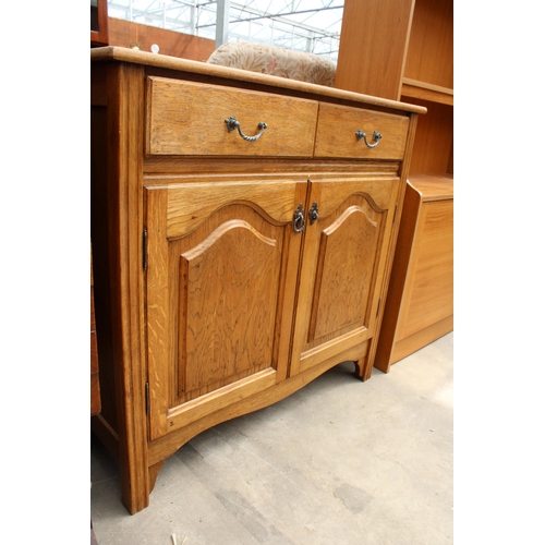 2910 - AN OAK SIDEBOARD ENCLOSING TWO DRAWERS AND TWO CUPBOARDS, 36