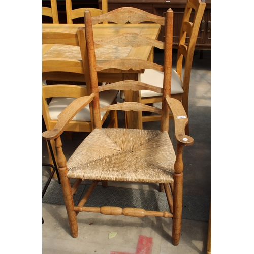 2973 - A GEORGE III STYLE OAK LADDER BACK ELBOW CHAIR WITH  RUSH SEAT