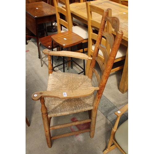 2973 - A GEORGE III STYLE OAK LADDER BACK ELBOW CHAIR WITH  RUSH SEAT