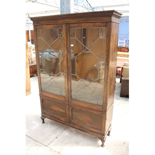 3006 - AN EARLY 20TH CENTURY OAK BOOKCASE WITH TWO GLAZED AND LEADED DOORS AND PANELLED DOORS TO BASE ON CA... 