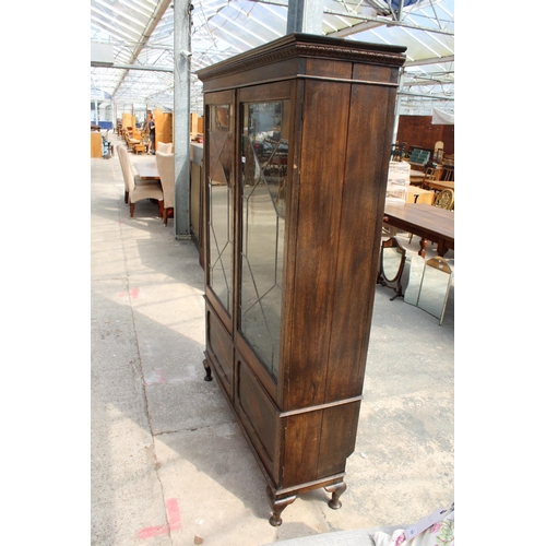 3006 - AN EARLY 20TH CENTURY OAK BOOKCASE WITH TWO GLAZED AND LEADED DOORS AND PANELLED DOORS TO BASE ON CA... 