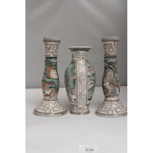 335 - A VINTAGE CHINESE ENAMELLED PORCELAIN VASE TOGETHER WITH A PAIR OF MATCHING CANDLESTICKS BOTH WITH R... 