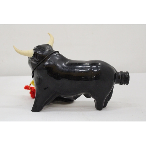 112 - A FULL SPANISH BULL BOTTLE TOGETHER WITH TWO PAIRS OF BULLFIGTHER CASTENETS