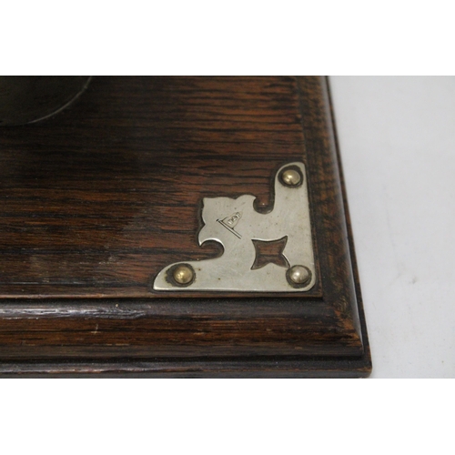 16 - A COW HORN GONG ON AN OAK PLINTH