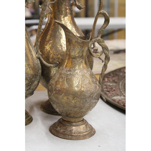 38 - TWO BRASS ETCHED EWERS WITH SERPENT HANDLE TOGETHER WITH A MIDDLE EASTERN BRASS DALLAH COFFEEPOT