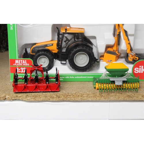 220 - FOUR SIKU 1:32 SCALE FARM MODELS TO INCLUDE A VALTRA TRACTOR WITH KUHN EMBANKMENT MOWER (AS NEW IN B... 