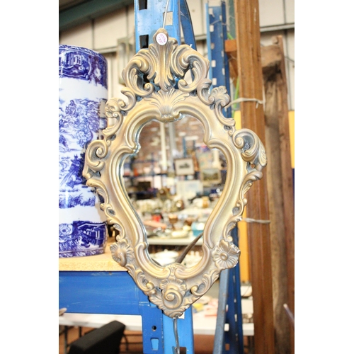 64 - AN ORNATE GILT FRAMED MIRROR