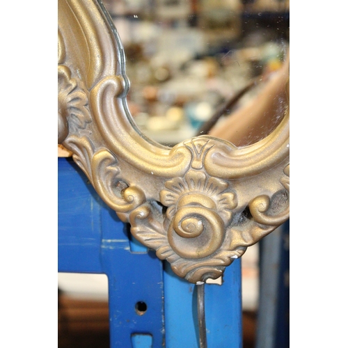 64 - AN ORNATE GILT FRAMED MIRROR