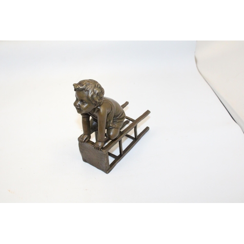 70 - A BRONZE FIGURE OF A CHILD ON A CHAIR - SIGNED