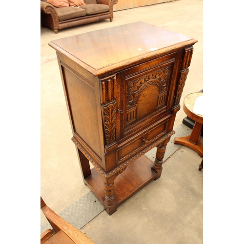 2910 - AN OAK GEORGIAN STYLE COCKTAIL CABINET WITH CARVED PANEL DOOR, SINGLE DRAWER AND SLIDE, ON OPEN BASE... 