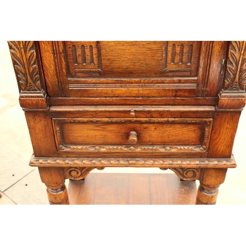 2910 - AN OAK GEORGIAN STYLE COCKTAIL CABINET WITH CARVED PANEL DOOR, SINGLE DRAWER AND SLIDE, ON OPEN BASE... 