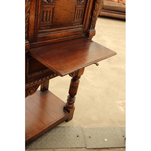 2910 - AN OAK GEORGIAN STYLE COCKTAIL CABINET WITH CARVED PANEL DOOR, SINGLE DRAWER AND SLIDE, ON OPEN BASE... 