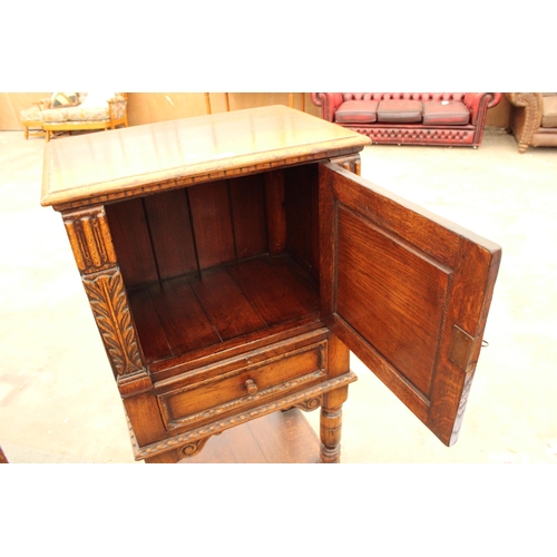 2910 - AN OAK GEORGIAN STYLE COCKTAIL CABINET WITH CARVED PANEL DOOR, SINGLE DRAWER AND SLIDE, ON OPEN BASE... 