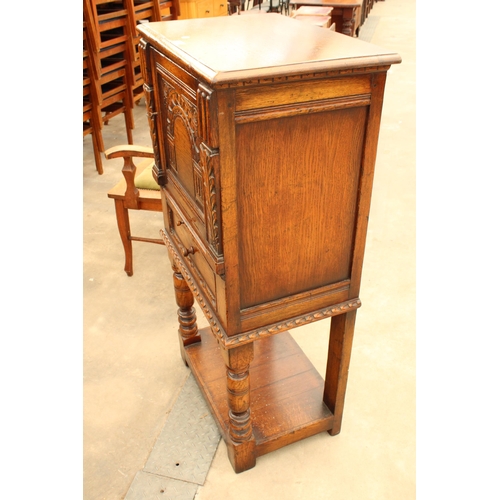 2910 - AN OAK GEORGIAN STYLE COCKTAIL CABINET WITH CARVED PANEL DOOR, SINGLE DRAWER AND SLIDE, ON OPEN BASE... 