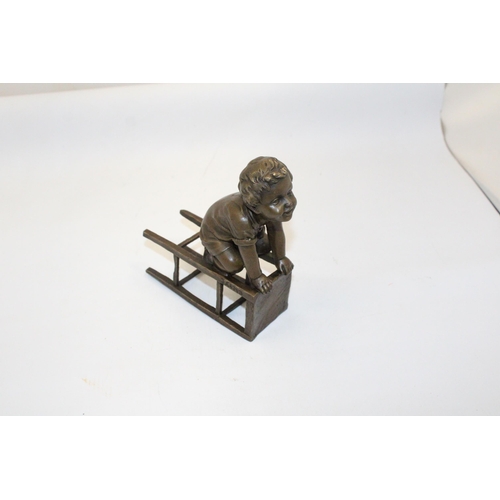 70 - A BRONZE FIGURE OF A CHILD ON A CHAIR - SIGNED