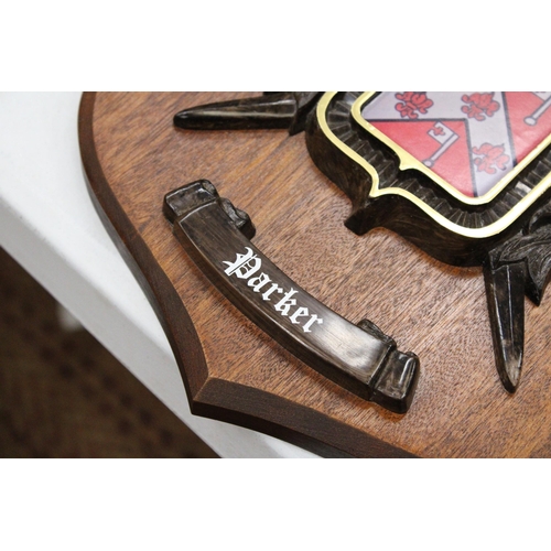 248 - A MAHOGANY SHIELD WITH A COAT OF ARMS FOR 'PARKER', 25CM X 32CM