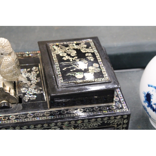 137 - AN ORIENTAL BOWING BIRD CIGARETTE DISPENSER/STORAGE BOX