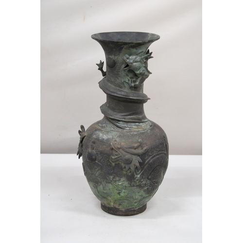 7 - A CHINESE BRASS RAISED BALUSTER VASE WITH FIGURAL MYTHICAL SCROLLING DRAGONS CHASING A FLAMING PEARL... 