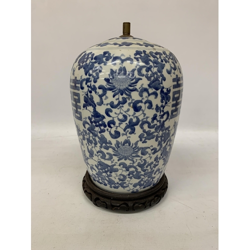 82 - A LARGE CHINESE OVOID BLUE AND WHITE CERAMIC TABLE LAMP DECORATED WITH LOTUS BLOSSOMS AND CHARACTERS... 