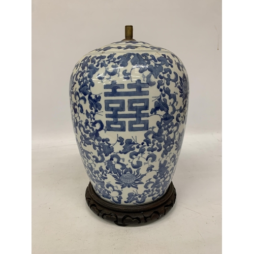 82 - A LARGE CHINESE OVOID BLUE AND WHITE CERAMIC TABLE LAMP DECORATED WITH LOTUS BLOSSOMS AND CHARACTERS... 