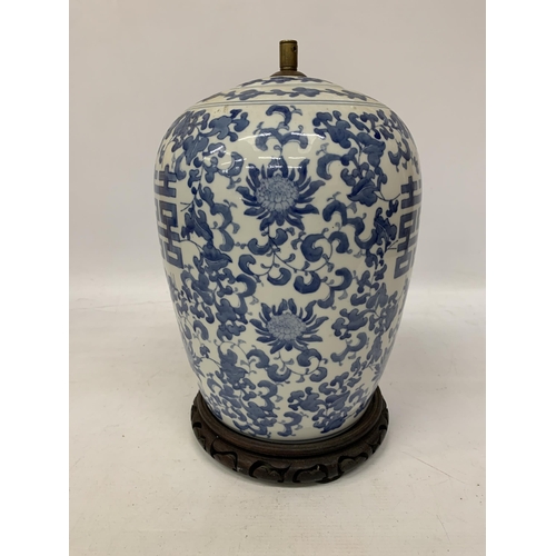 82 - A LARGE CHINESE OVOID BLUE AND WHITE CERAMIC TABLE LAMP DECORATED WITH LOTUS BLOSSOMS AND CHARACTERS... 