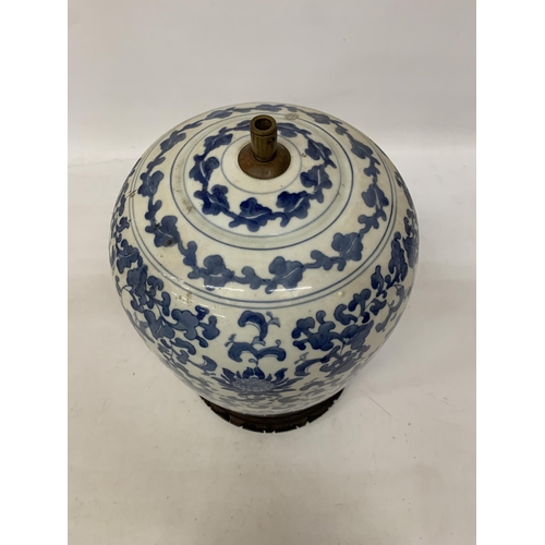 82 - A LARGE CHINESE OVOID BLUE AND WHITE CERAMIC TABLE LAMP DECORATED WITH LOTUS BLOSSOMS AND CHARACTERS... 