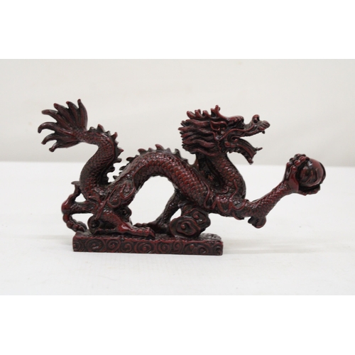 289 - A RED RESIN ORIENTAL DRAGON, HEIGHT 12CM, LENGTH 23CM