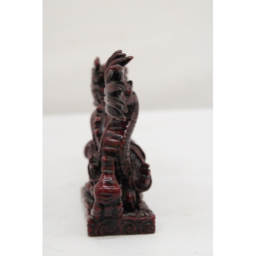 289 - A RED RESIN ORIENTAL DRAGON, HEIGHT 12CM, LENGTH 23CM