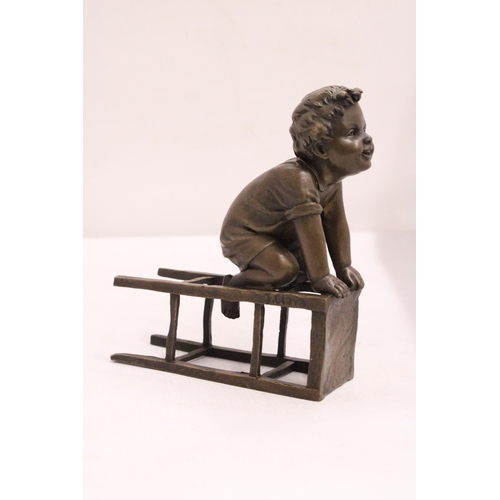 333 - A BRONZE FIGURE OF A CHILD ON A CHAIR - SIGNED