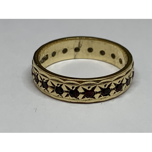 513 - A 9 CT GOLD BAND WITH GARNETS ALL THE WAY ROUND SIZE L