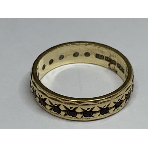 513 - A 9 CT GOLD BAND WITH GARNETS ALL THE WAY ROUND SIZE L