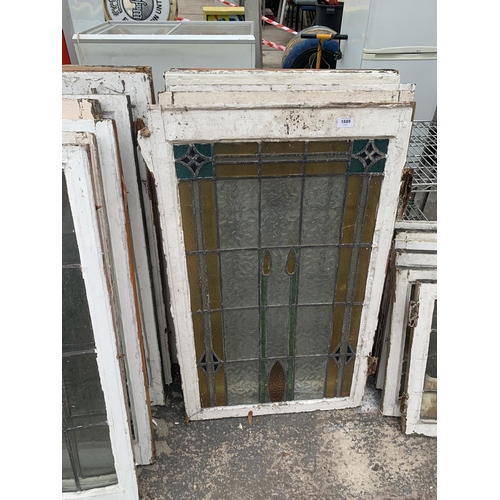 1889 - A LARGE ASSORTMENT OF WOODEN FRAMED STAIN GLASS WINDOWS