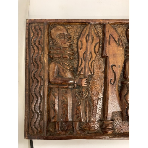 105 - AN EARLY CARVED AFRICAN WOODEN PLAQUE - 61 X 31 CM